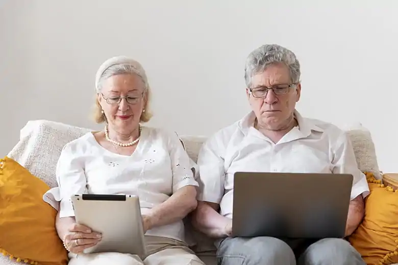web design para casal de idosos em frente do notebook